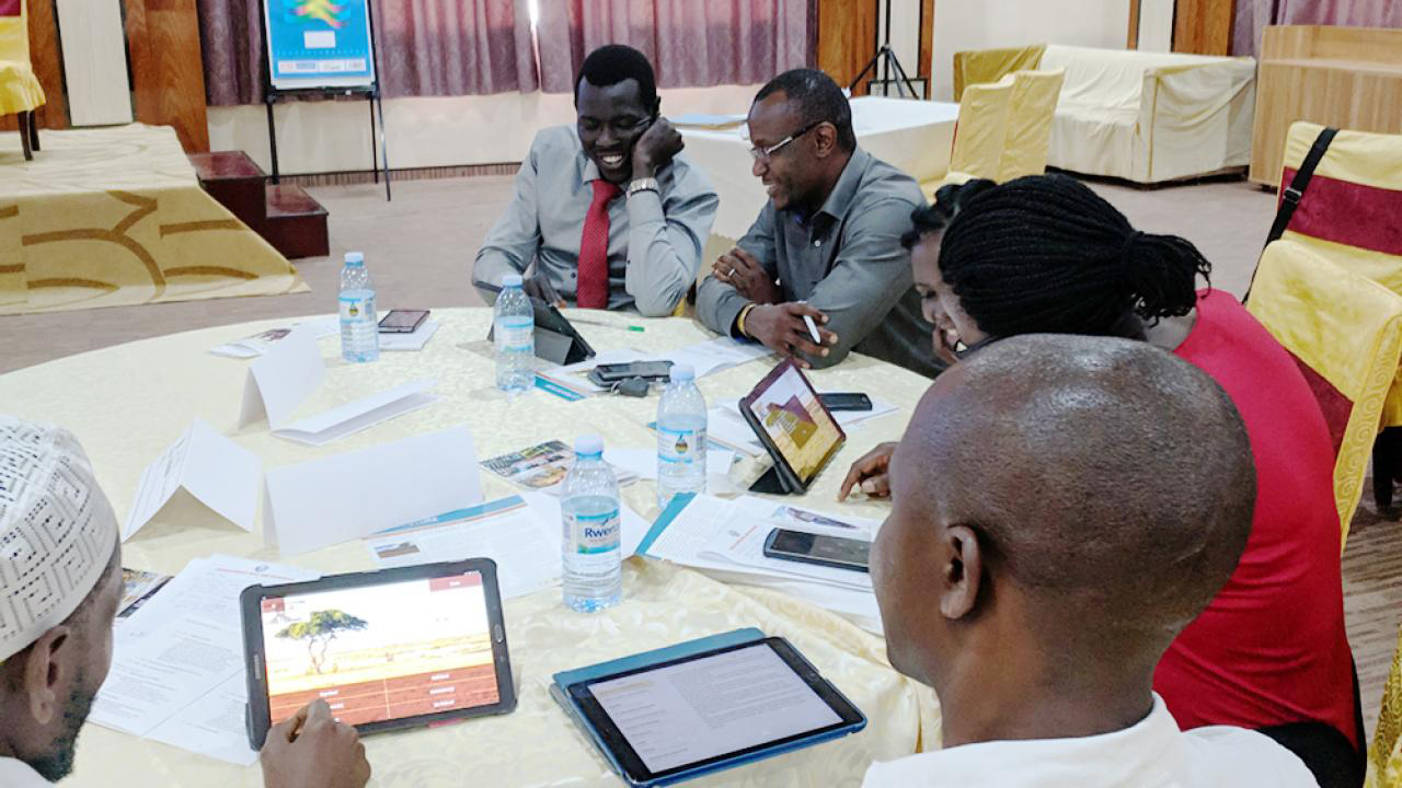 Uganda event participants try SimPastoralist, an index insurance research and education tool developed by Andrew Hobbs at UC Davis