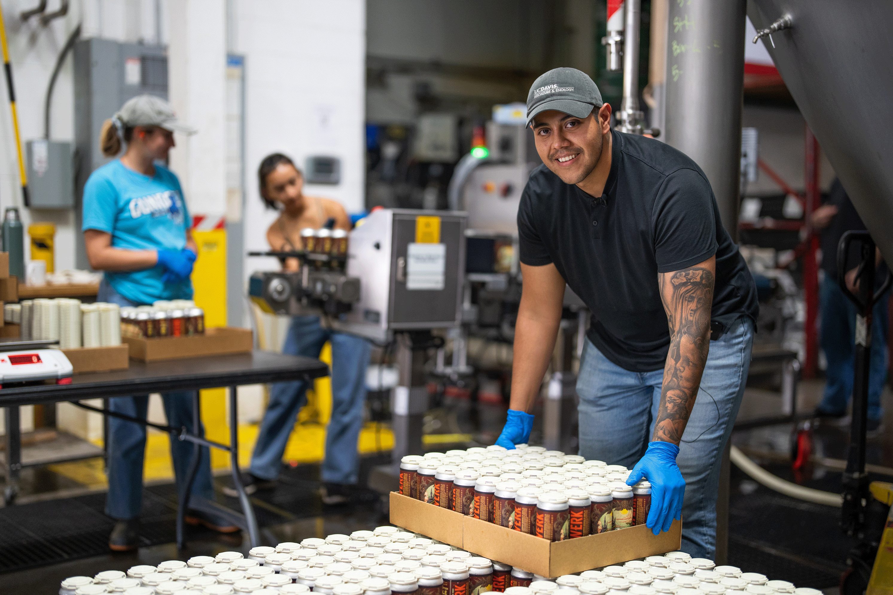 Moises Gomez, winner of the 2022 IronBrew competition, works with his team to stack cans of their beer at the Sudwerk Brewery.