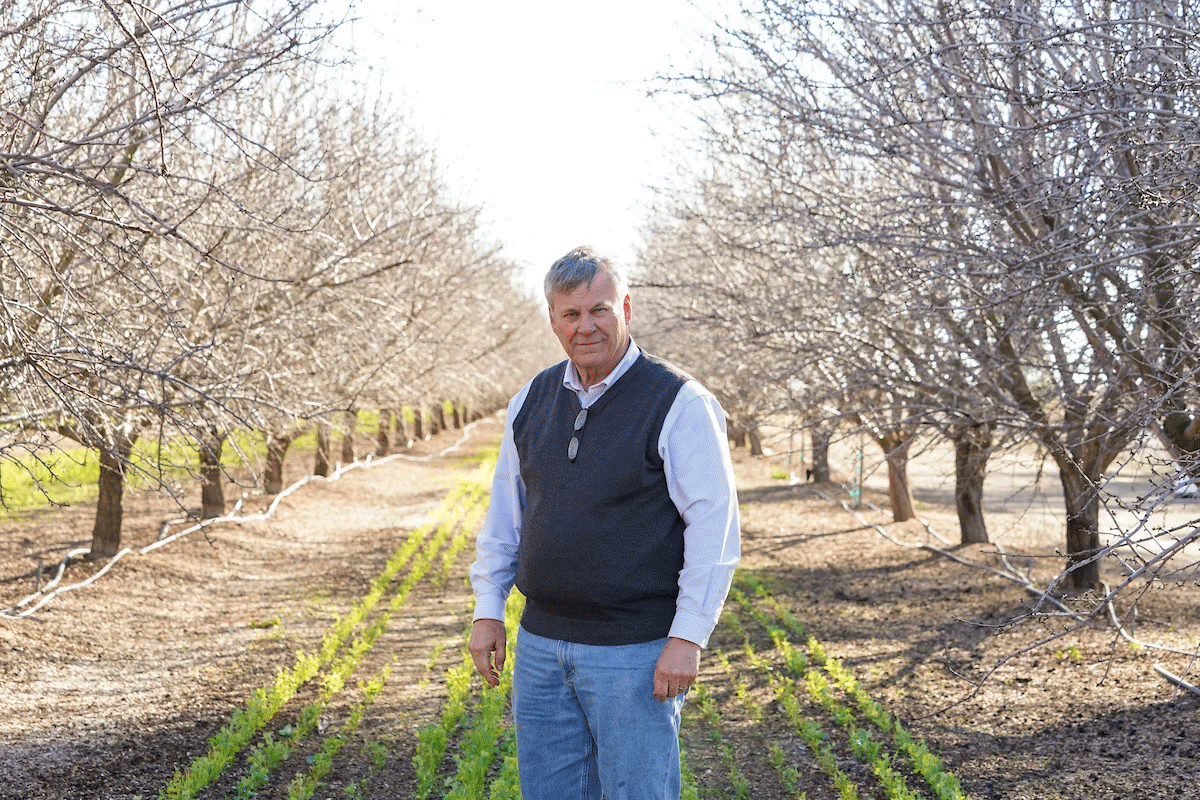 Kirk Pumphrey of Westwind Farms stands in his almond orchards in Yolo County, California. He’s using a precision metering and almond mulch to conserve groundwater. (Karin Higgins/UC Davis)