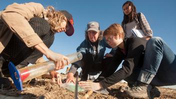 Professor Kate Scow (center, in hat) help students analyze infiltration rates in different soils at Russell Ranch Sustainable Agriculture Facility. (Gregory Urquiaga/UC Davis)