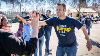 UAP Advisor Greg Anderson high fives a student at an Aggie Jumpstart event.