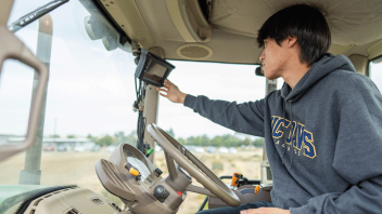 A student practices driving a tractor during class.