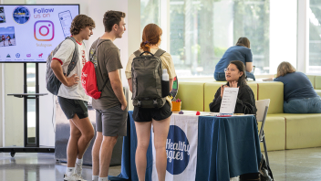 Wendy Liang, a senior majoring in clinical nutrition, chats with students who stopped by her table in the ARC lobby. 