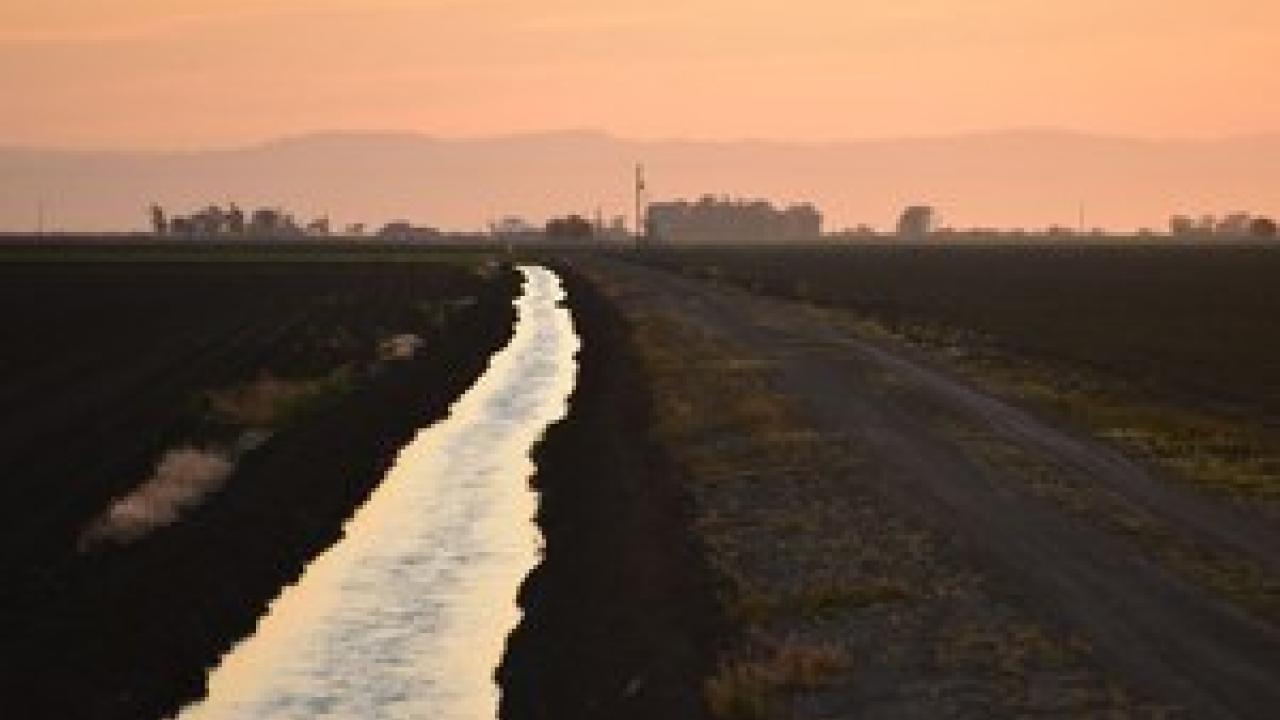 As the sun sets on this Merced County farm, water is conveyed in an unlined canal to more distant fields. State regulators increasingly are seeking to know how much water is being used throughout the state, and by whom. (Josh Viers | UC Merced)