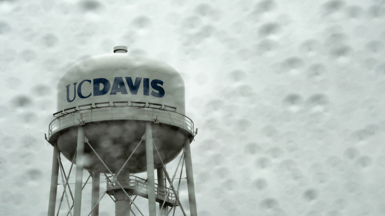 The UC Davis Water Tower in the rain during a heavy rain storm on January 11, 2023, as seen thru a rainy splattered window.