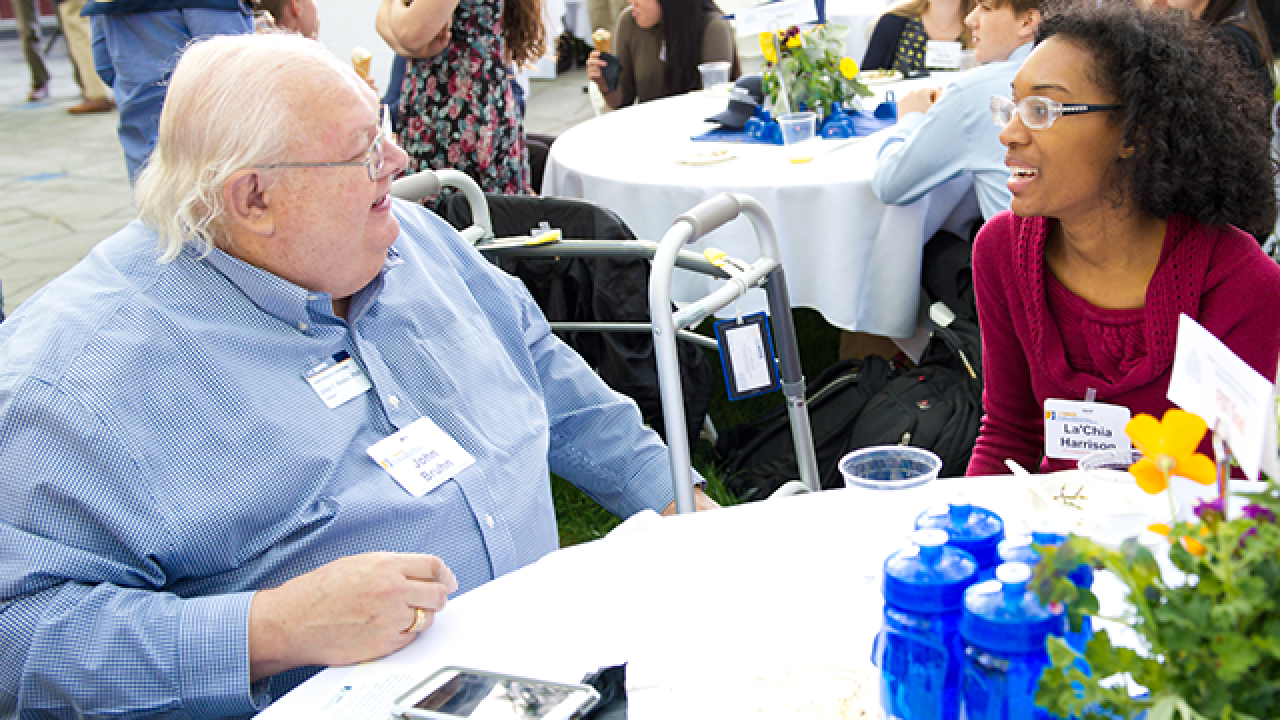A donor talks with an undergrad student at a scholarship event.