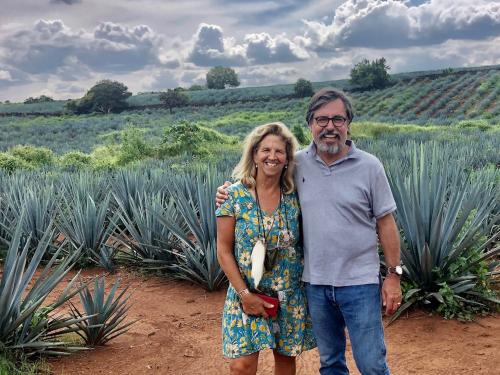 Lisa and Stuart Woolf stand in front of agave plants. The Central Valley farmers have a test plot of agave plants. (Stuart Woolf)