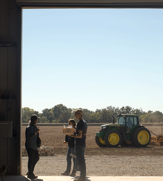 The view from inside the barn onto the Russell Ranch fields as a tractor passes during Soil Science 100 class at Russell Ranch Farm.