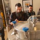 Professor Charlie Bamforth, left, and brewer Joe Williams, second from left, confer as beer is brewed in the UC Davis brewery. (Gregory Urquiaga/UC Davis)