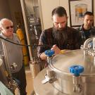 Professor Charlie Bamforth, left, and brewer Joe Williams, second from left, confer as beer is brewed in the UC Davis brewery. Williams is UC Davis’ first endowed brewer, thanks to a gift received in the last fiscal year.