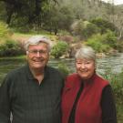 Tom and Ginny Cahill at Putah Creek and the land they donated to the university in the background.