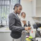 A father with baby in a kitchen.