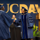 A student shakes hands with Dean Helene Dillard.