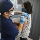 A woman receives her COVID-19 vaccine shot at a clinic.